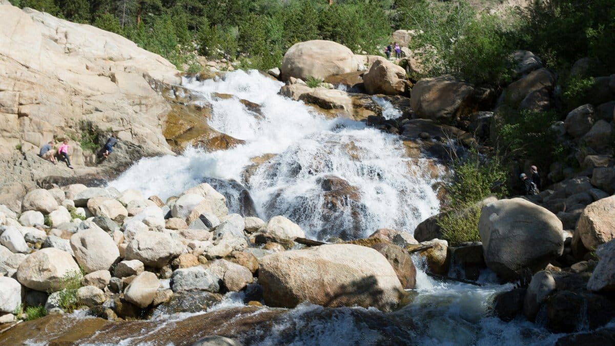 Captivating view of a waterfall cascading over rocks in Rocky Mountain National Park, a perfect travel and nature scene. via Pexels