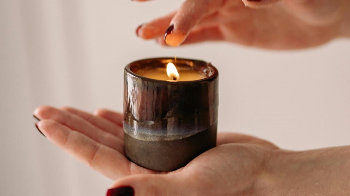 Close-up of hands holding a lit candle, showcasing elegance and tranquility. via Pexels