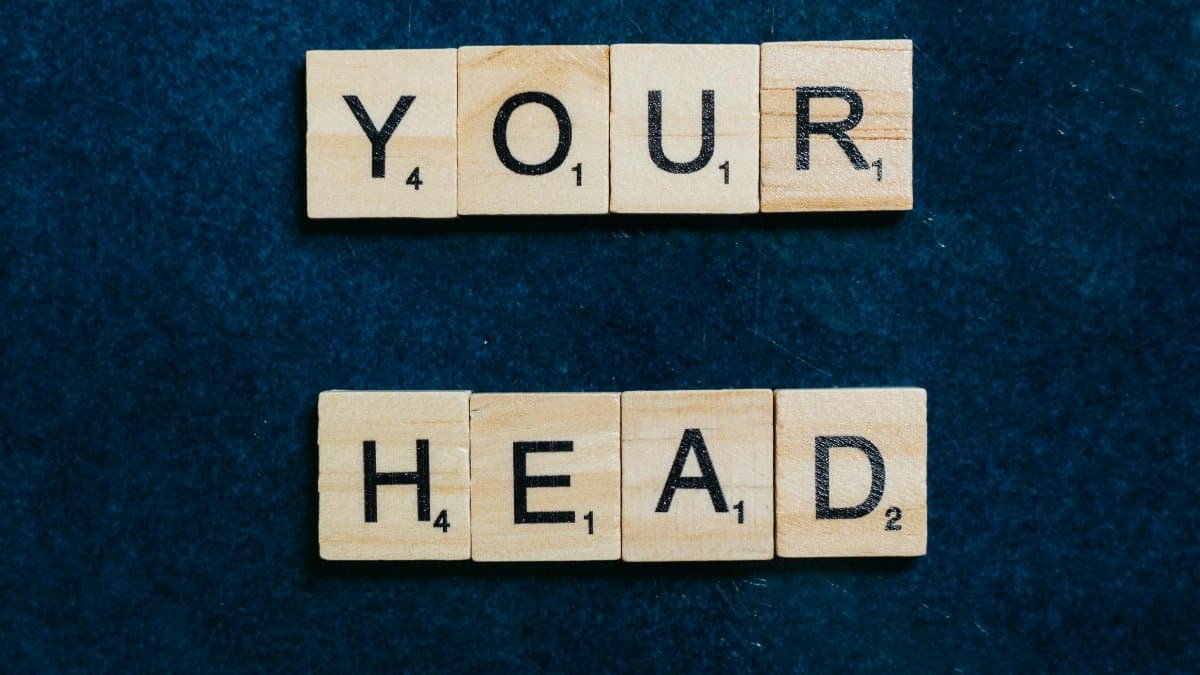 Scrabble tiles spelling &#039;Keep your head up&#039; on a textured surface. via Pexels