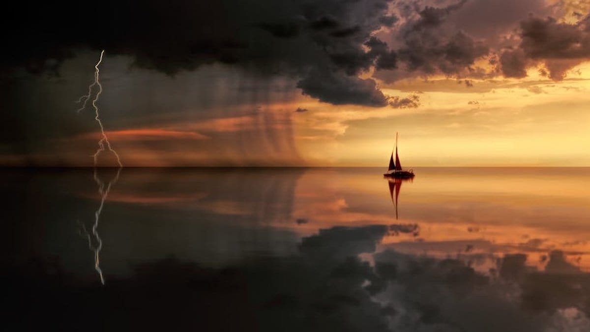 A striking seascape featuring a sailboat, lightning, and storm clouds at sunset. via Pexels