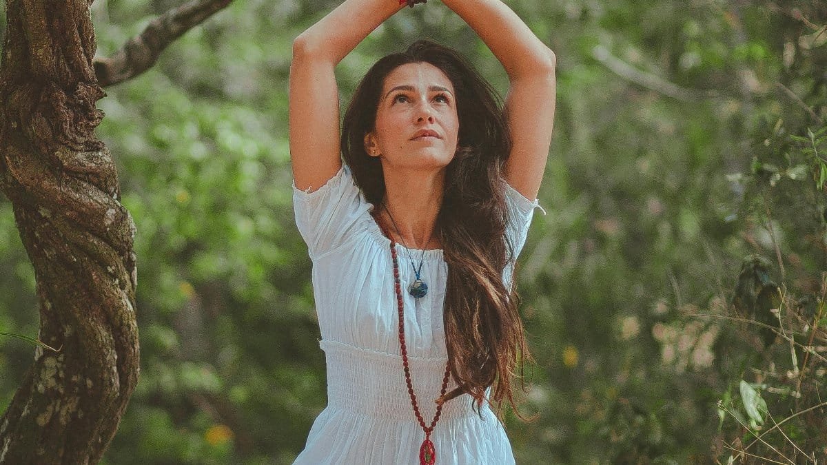 Woman meditating in a peaceful forest setting, embracing calmness and balance. via Pexels