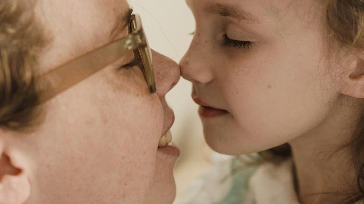 Mother and daughter sharing a gentle affectionate moment indoors. via Pexels