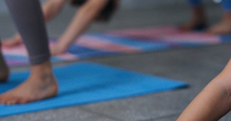 A group of women performing yoga poses on mats in an indoor setting, emphasizing fitness and mindfulness. via Pexels