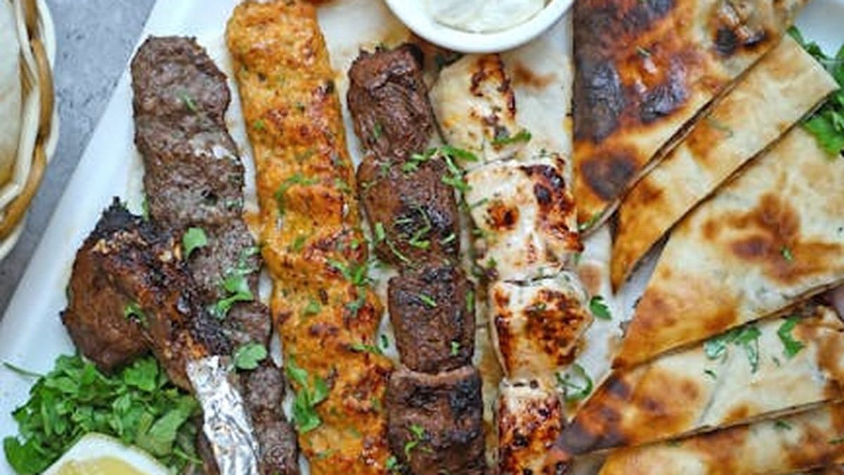 A mouth-watering assortment of grilled meats served with pita bread and fresh lemon. via Pexels