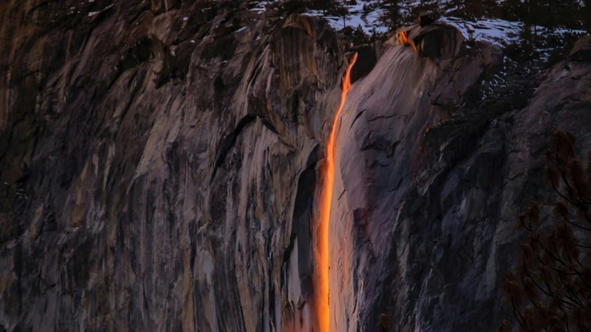 Sunset glow creates a fiery waterfall effect on a snowy cliff. via Pexels