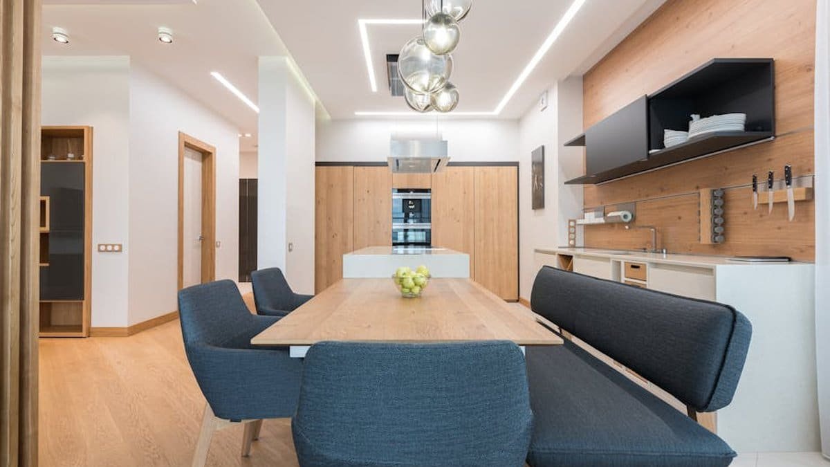 Dining zone with wooden table and soft chair and cushion placed in modern kitchen of spacious apartment via Pexels