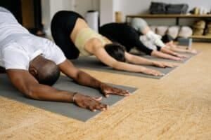 Man in white shirt doing stretching in yoga class