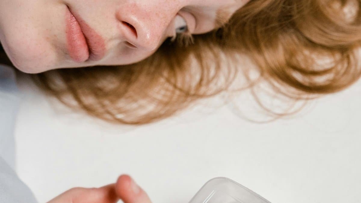 A woman overcomes anxiety by observing a Madagascar hissing cockroach in a plastic container. via Pexels