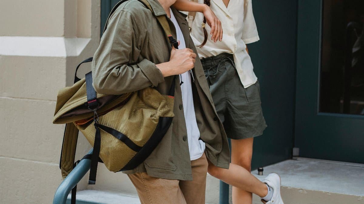 Cheerful young couple relaxing on a city stairway, enjoying casual conversation. via Pexels