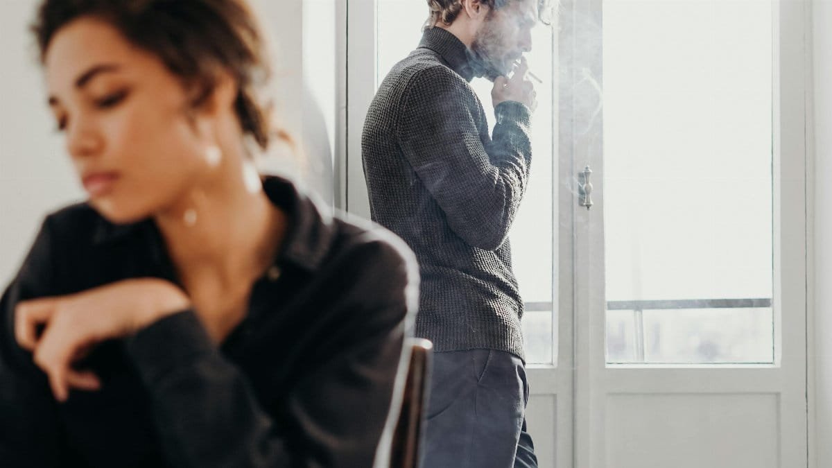 A couple experiencing tension and introspection indoors with a bright window. via Pexels