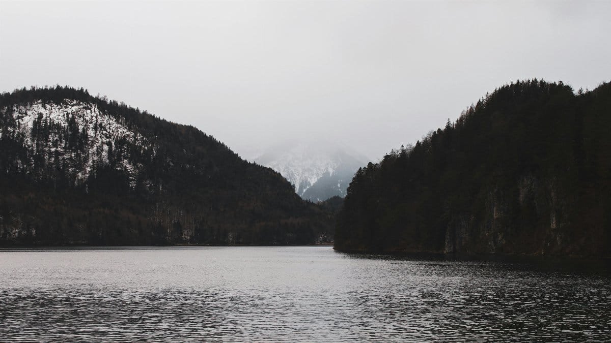 Placid lake surrounded by misty winter mountains in Schwangau, Germany. via Pexels