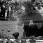An indigenous woman performs a ritual with an audience watching closely in Mexico. via Pexels