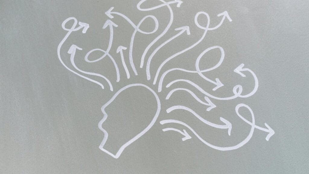 Chalk drawing of a head with swirling arrows represents mental activity and thought process. via Pexels