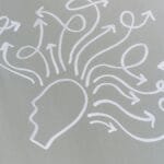 Chalk drawing of a head with swirling arrows represents mental activity and thought process. via Pexels