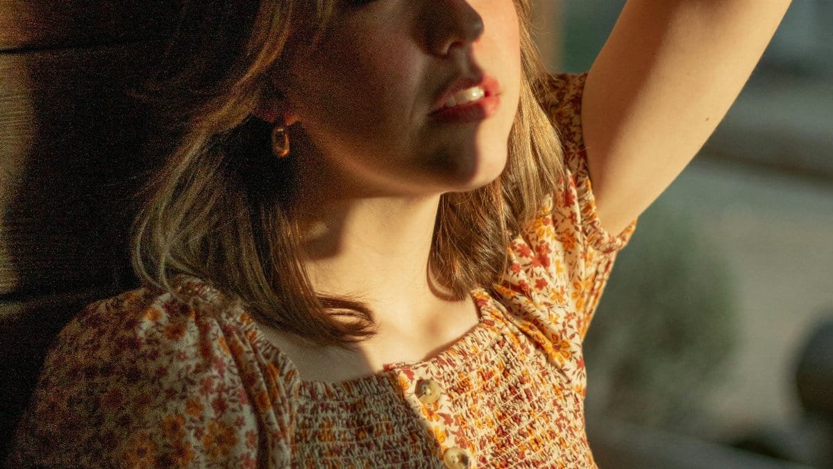 A woman basks in the soft glow of sunlight indoors, evoking feelings of peace and contemplation. via Pexels