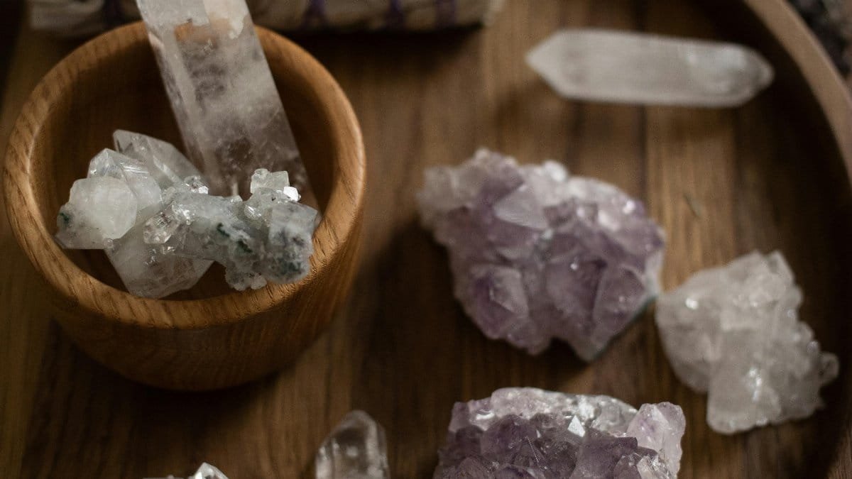 A collection of healing crystals on a wooden tray for alternative therapy and crystal healing. via Pexels