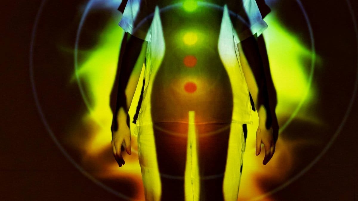 Human silhouette with vibrant chakra energy projection, symbolizing balance and spirituality. via Pexels