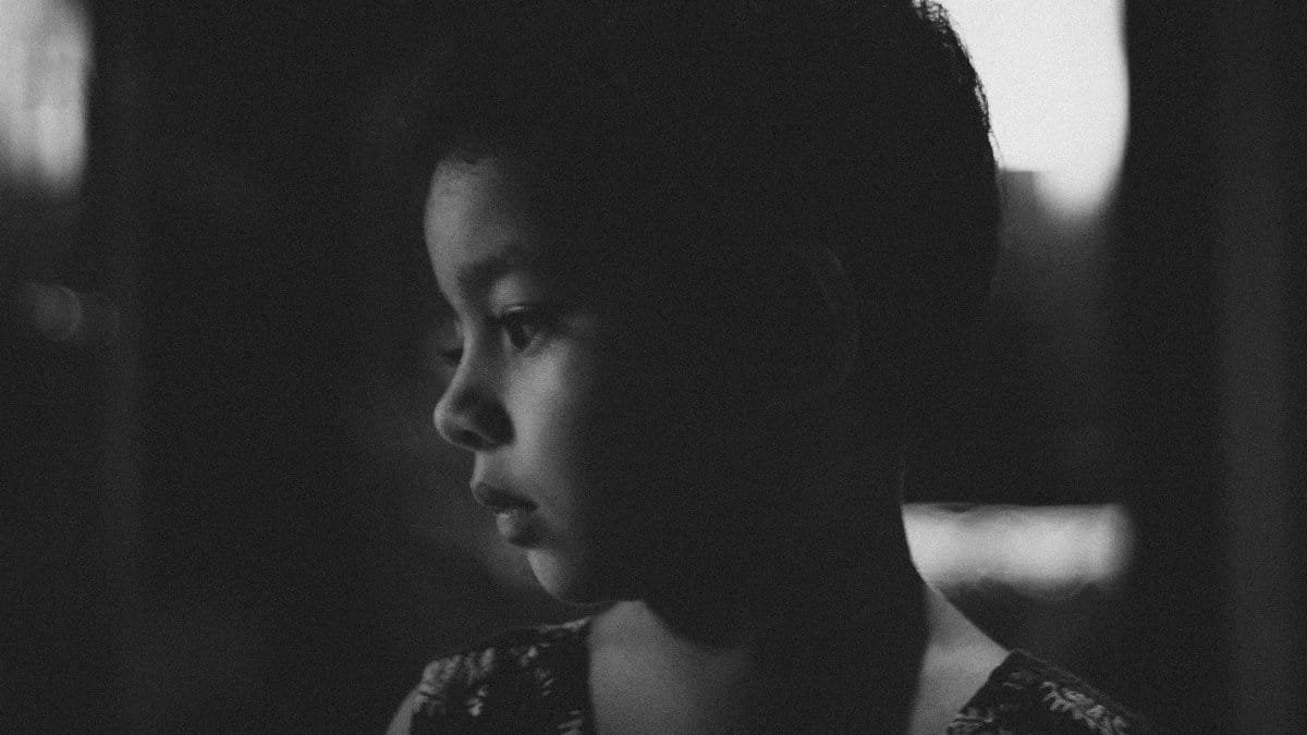 A candid black and white portrait of a thoughtful child in side view. via Pexels