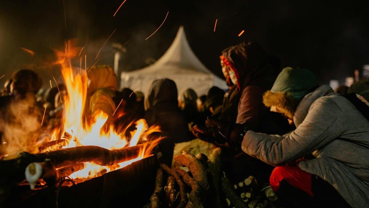 People gather around a warming bonfire at night in Central Java's cool atmosphere.