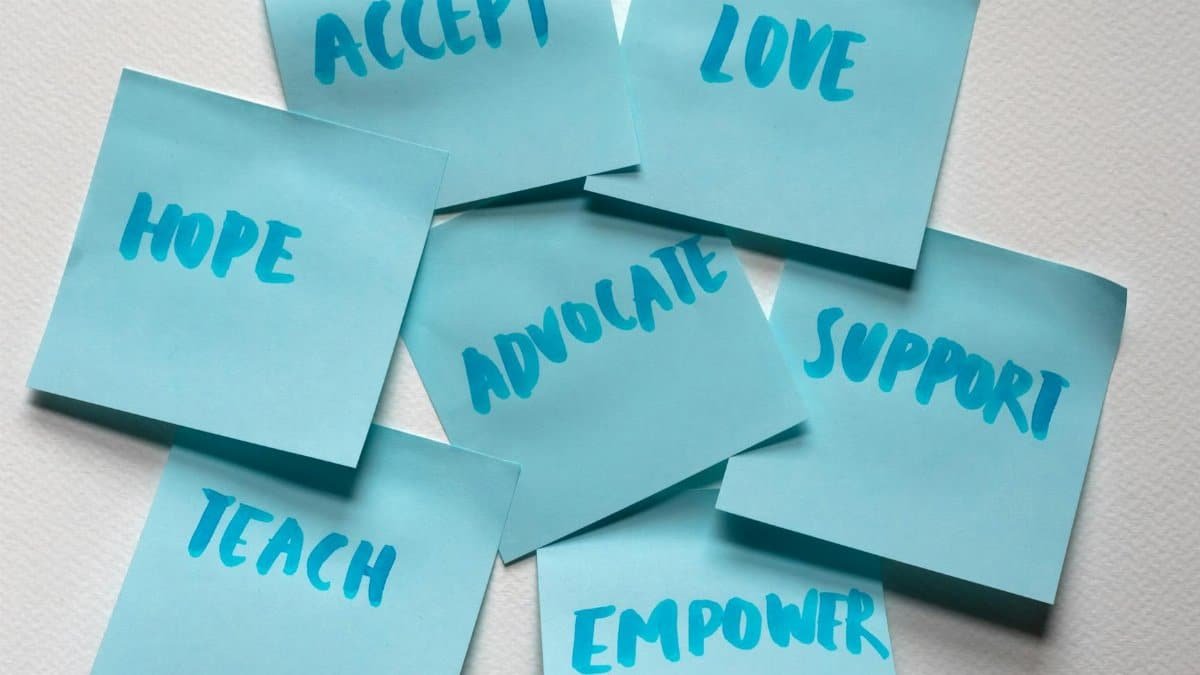 Close-up of blue sticky notes featuring positive words like hope and love.