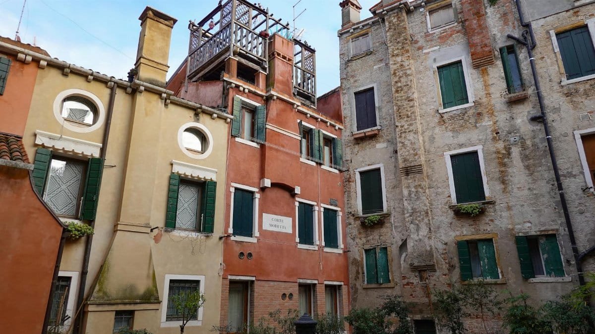 A quaint Venetian courtyard featuring vibrant historic buildings with classic architecture.