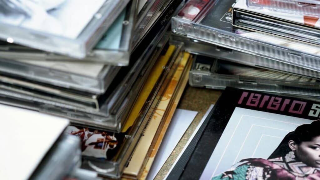 Close-up of stacked music CDs with retro album covers and clear cases in selective focus.