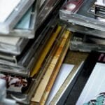 Close-up of stacked music CDs with retro album covers and clear cases in selective focus.