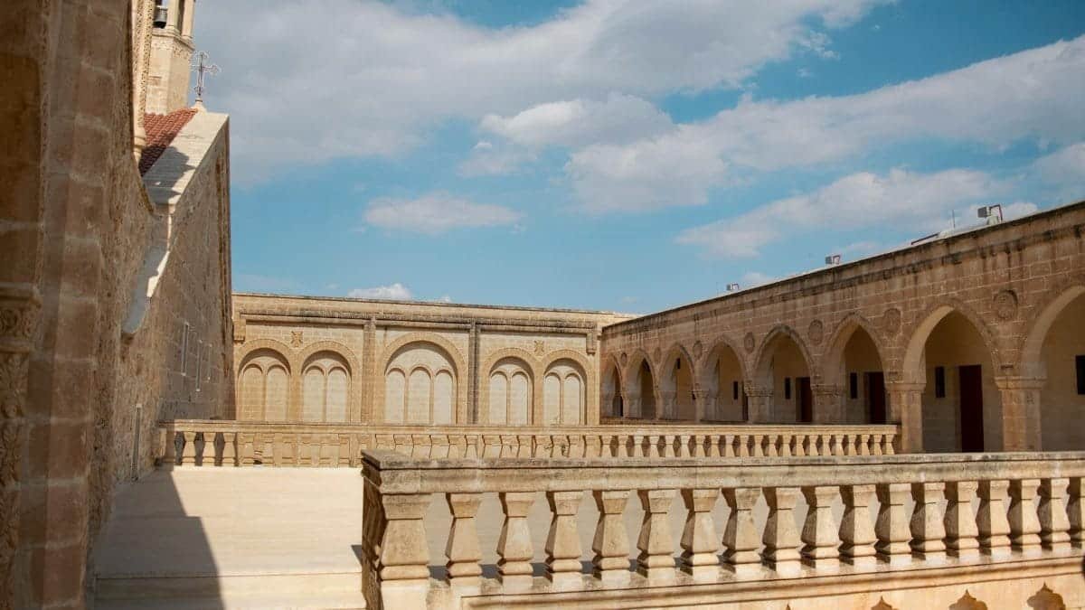 Historic Mor Gabriel Monastery in Midyat, showcasing ancient architecture under a bright sky.