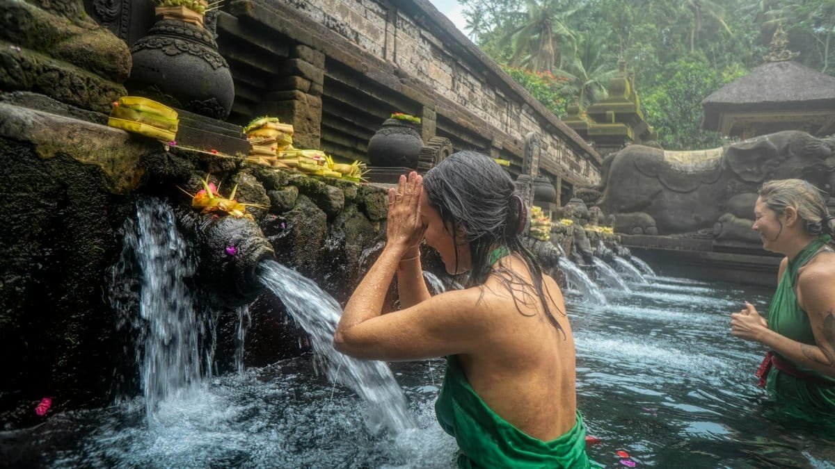 Women participating in a sacred water purification ritual at Pura Tirta Empul Temple in Bali, Indonesia.
