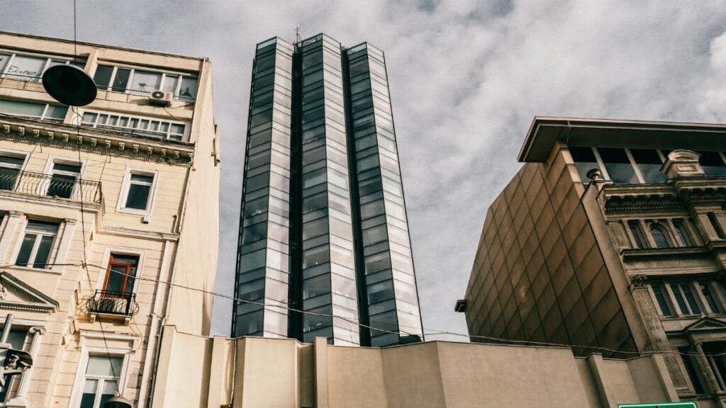 Low-angle shot of a modern skyscraper amidst historic architecture in Istanbul, Turkey.