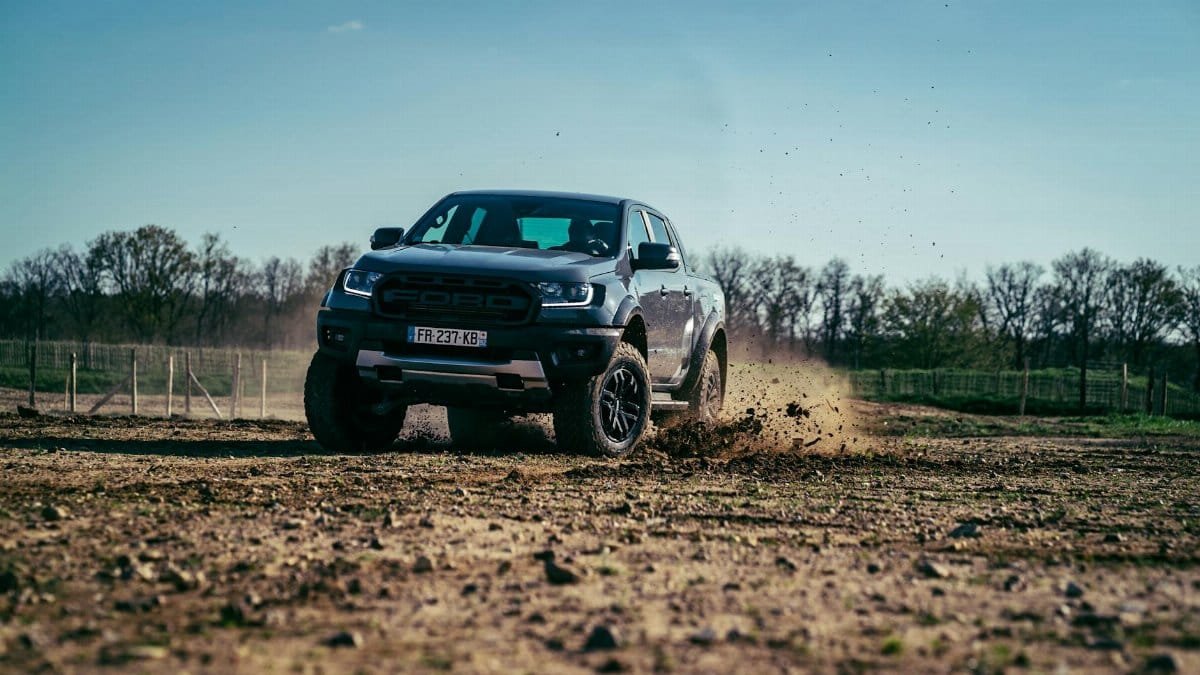 A rugged SUV driving off-road, kicking up dirt and showcasing dynamic movement.