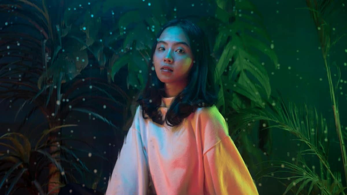 Artistic portrait of a woman with colorful lights and dreamy ambiance, evoking a fantasy mood.