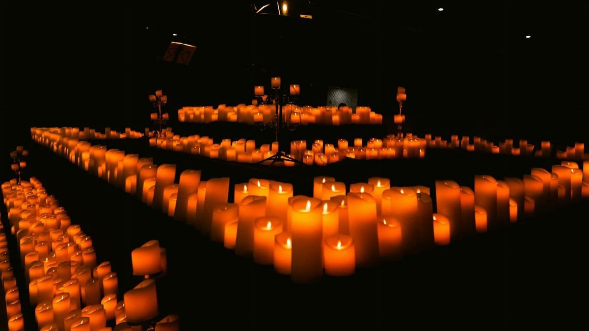 A captivating display of numerous candles creating a warm glow in a dark setting, exuding tranquility.