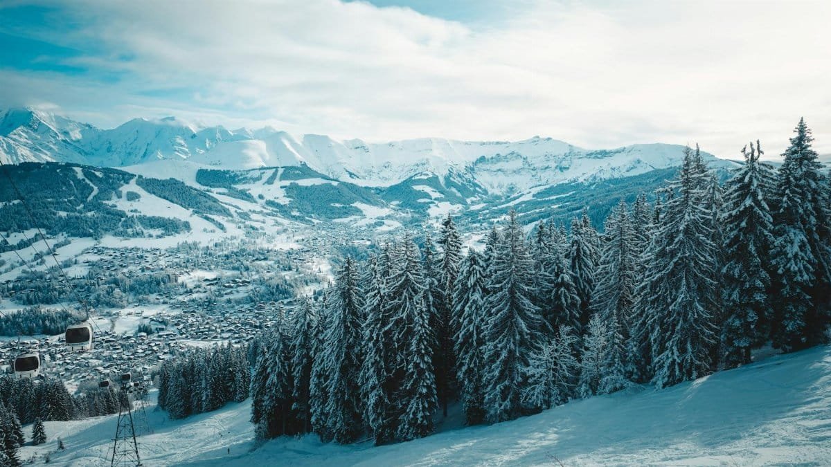 Breathtaking view of snow-covered trees and mountains in Megève, France, capturing winter's serene beauty.