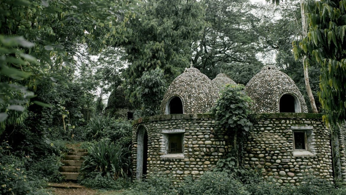 Discover serene stone meditation huts nestled in a lush jungle setting, offering peace and tranquility.