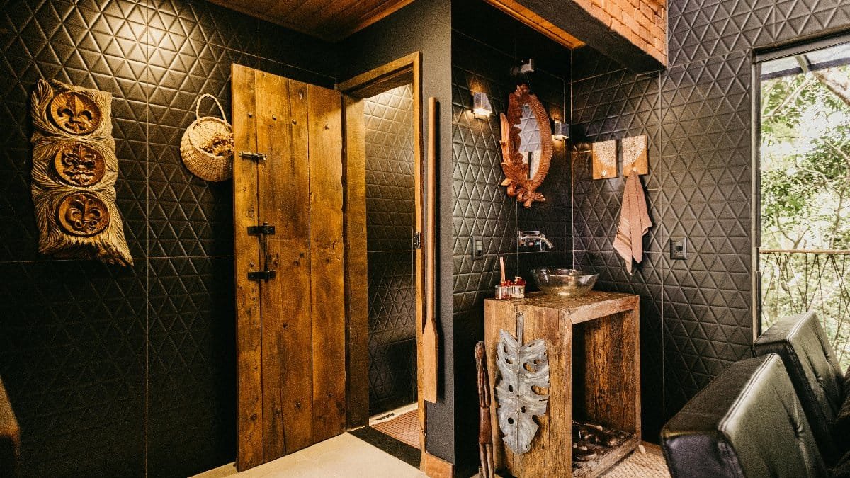 Cozy rustic bathroom interior with wooden elements and tribal art in Espírito Santo.