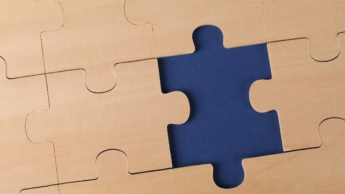 Close-up of an unfinished wooden puzzle with a missing piece, highlighting problem-solving concepts.
