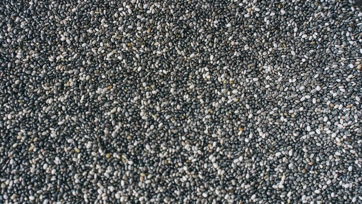A detailed view of numerous small black chia seeds forming a textured background.
