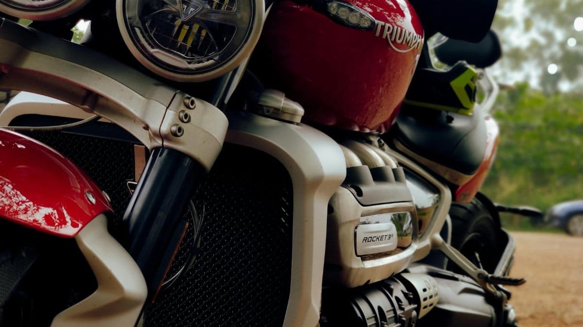 Detailed view of the Triumph Rocket 3 motorcycle engine and headlights, emphasizing design and power.