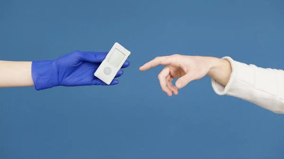 A medical professional hands a glucometer to a patient, symbolizing diabetic care and awareness.
