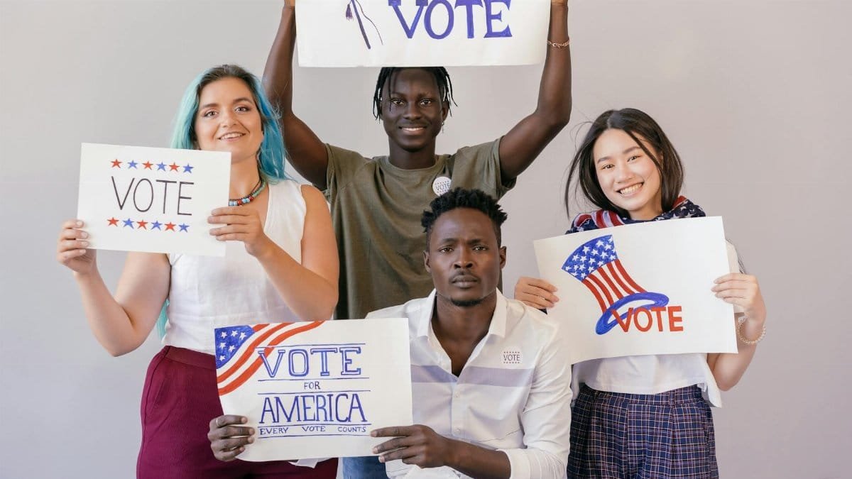 Diverse group of young adults proudly holding signs to encourage voting in America.