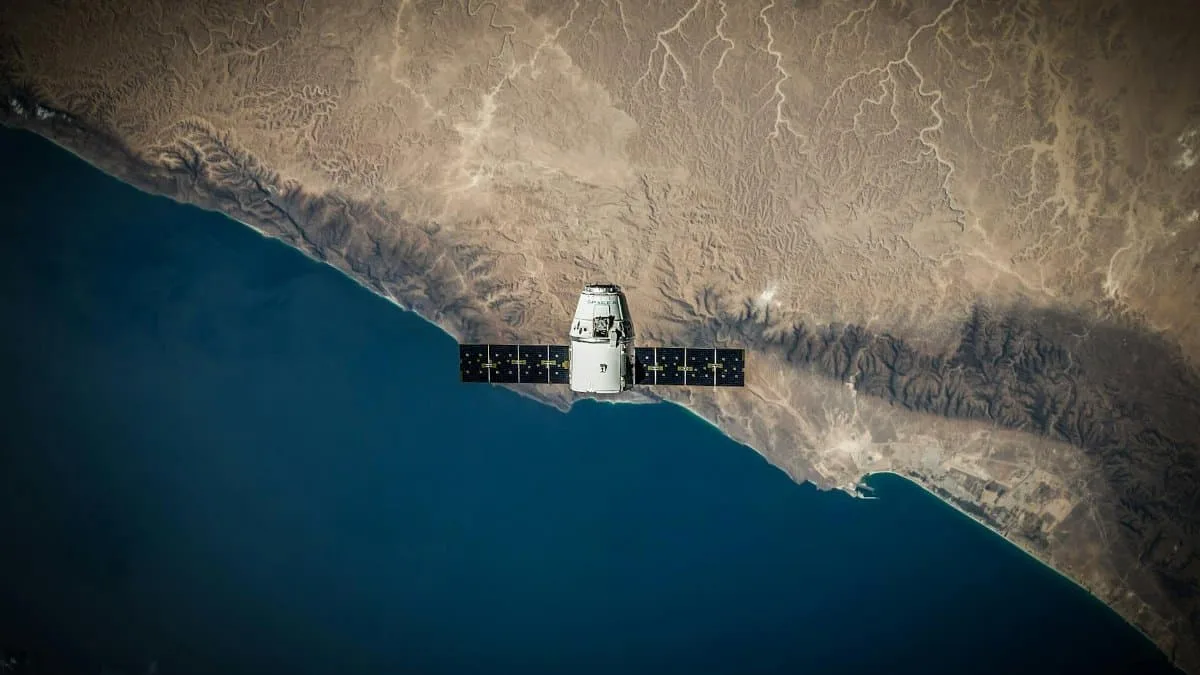 A satellite hovering above Earth's coastline, captured from space.