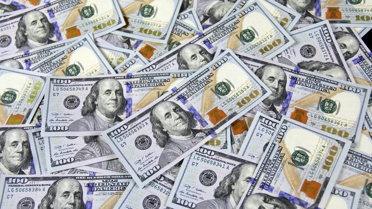 Pile of US hundred dollar bills depicting financial success and wealth.
