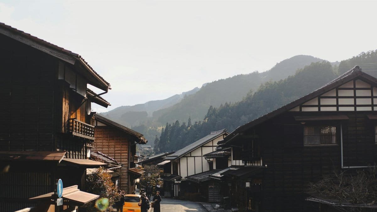 Charming traditional Japanese village with wooden houses nestled in a picturesque mountain setting.
