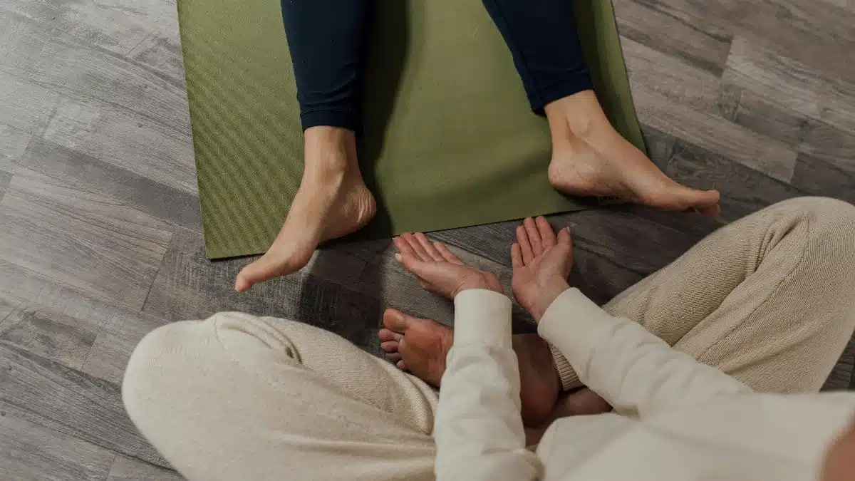A calming indoor meditation session with focus on feet and hands posture.