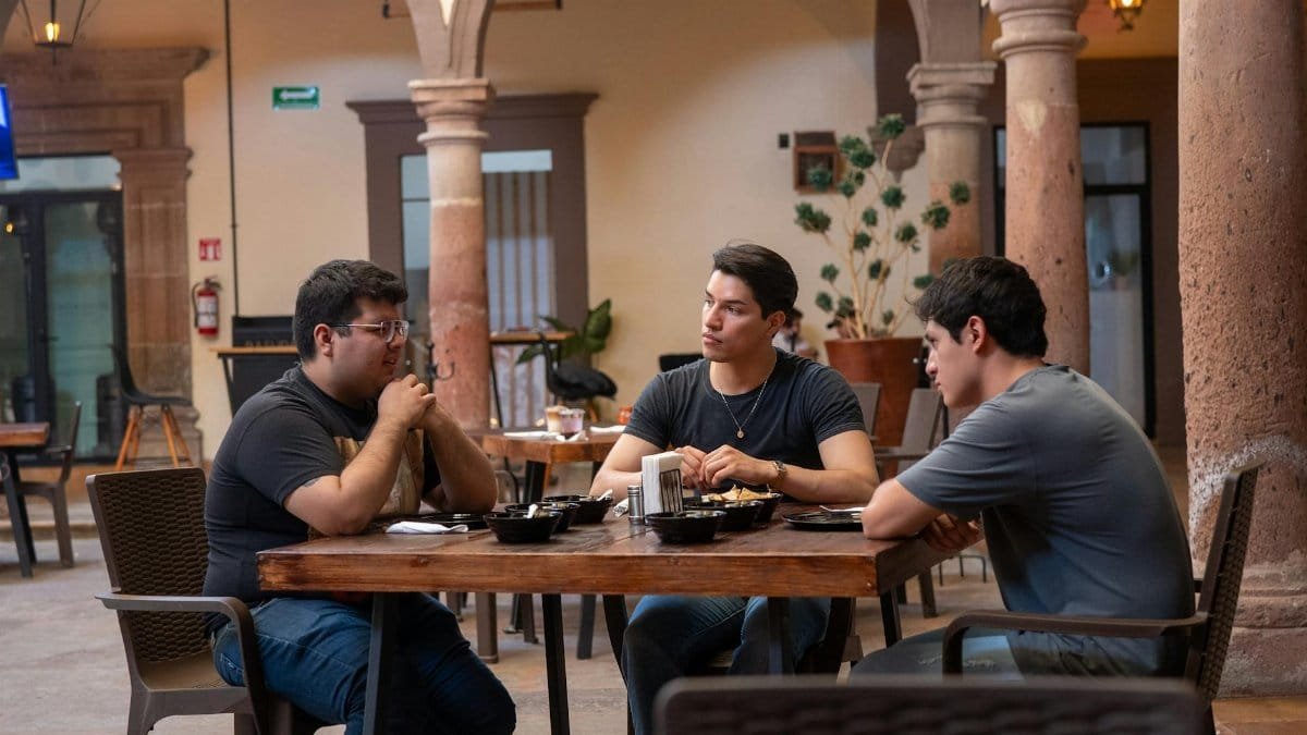 Three men enjoying Mexican food at an indoor courtyard restaurant in Guanajuato, Mexico.