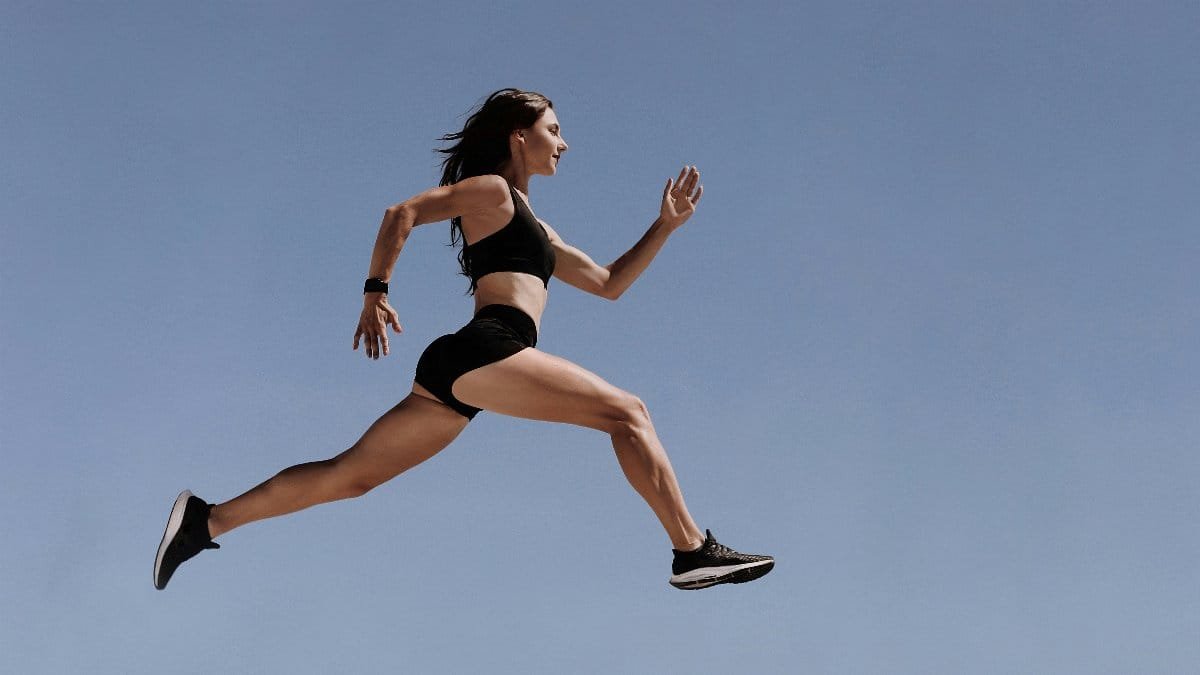 Athletic woman in motion leaping across the sky demonstrating energy and fitness outdoors.