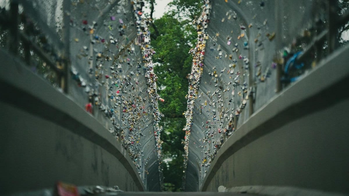 Metal pedestrian bridge in Houston adorned with hundreds of love locks, symbolizing attachment and commitment.