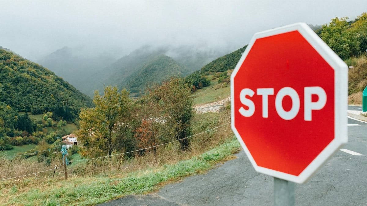 Captivating mountain landscape featuring a prominent red stop sign in the foreground.