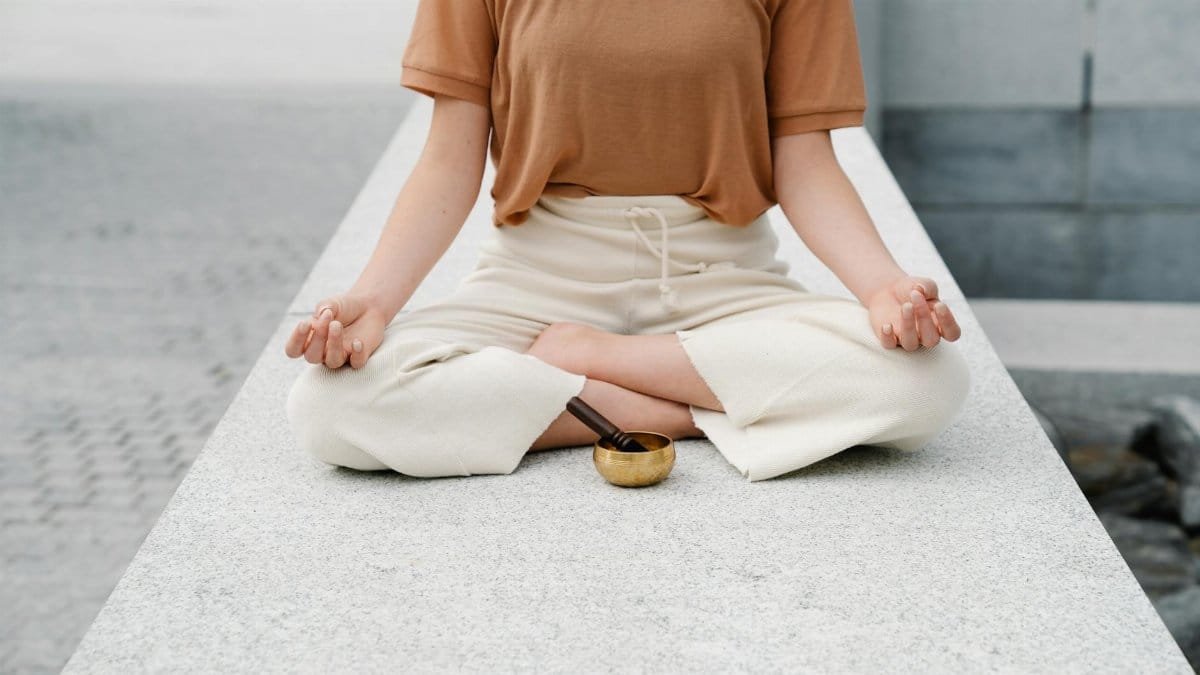 A person meditating outdoors with a singing bowl, embracing serenity and mindfulness.